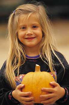 Girl holding pumpkin at Baxter Barn